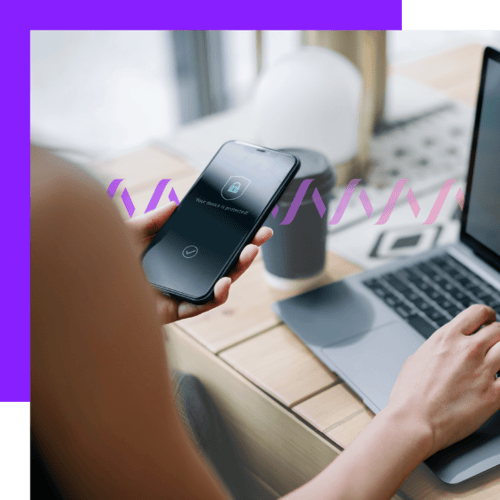 Photoillustration of a woman holding a cell phone in her left hand with a lock and badge icon on it to indicate security; with her right hand, she types on a Mac laptop