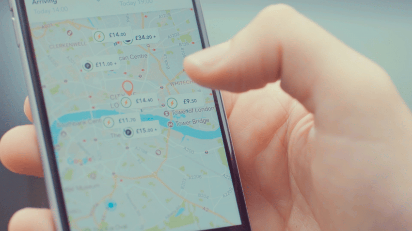 JustParkアプリの地図が表示された携帯電話を握る手
